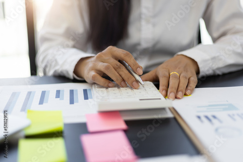 Close up woman accountant work on financial documents and use budget analysis calculators.