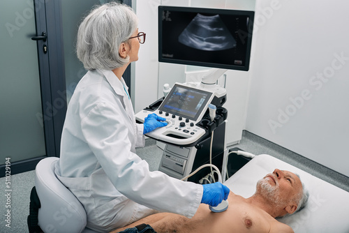 Fotografia Heart ultrasound exam for senior man with ultrasound specialist while medical ex