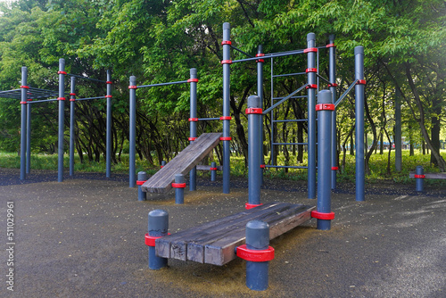 Playground for workout in a public park with trees in background
