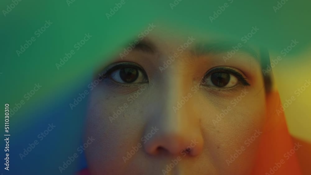 Portrait young teen queer transgender asia people look at camera under colorful stripes flag. Closeup eye face cry sad hiding true self identity in gay LGBTQ LGBT bisexual mental illness problem.  Stock ビデオ | Adobe Stock 