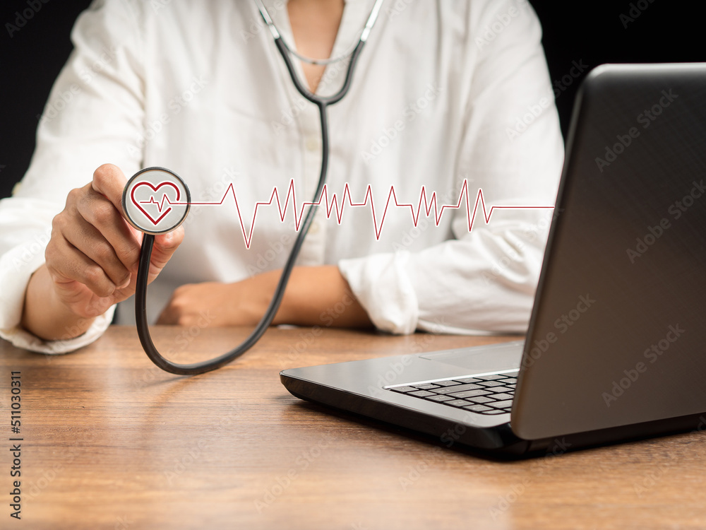 Close-up of hand doctor holding a stethoscope with a red heart icon and red wave while sitting in the hospital Close-up of hand doctor holding a stethoscope with a red heart icon and red wave while sitting in the hospital