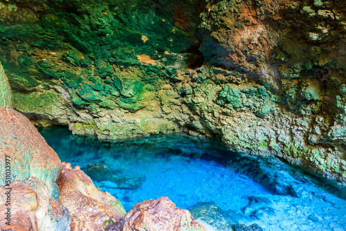 View of beautiful natural pool of crystal clear water formed in a rocky cave with stalagmites and stalagmites. Kuza cave in Zanzibar  Tanzania