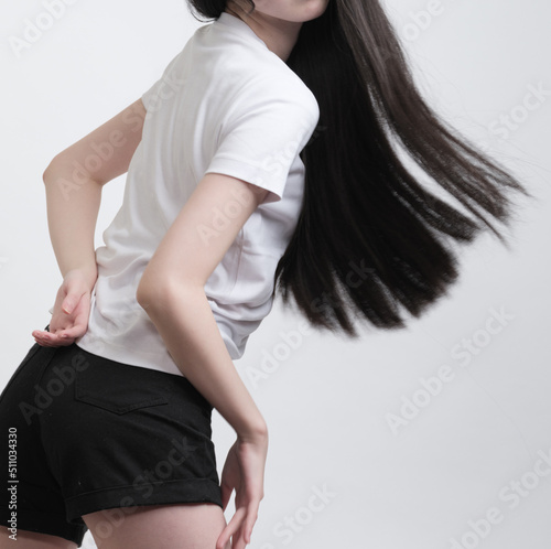 動きの速い振り向きでポージングをしている長い黒髪の若い女性モデル