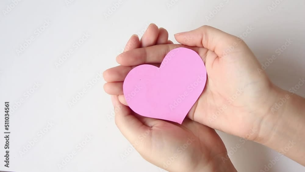 Hand holding pink heart on wood table background, healthcare, organ donation, love, hope and giving concept. Hand holding pink heart on wood table background, healthcare, organ donation, love, hope and giving concept.