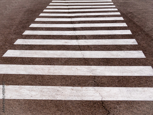 Pedestrian crossing on an empty asphalt city street, close-up.