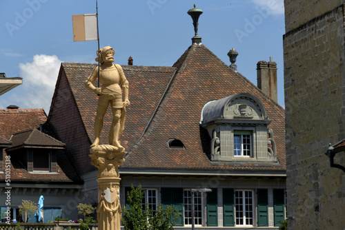 Stone fountain with soldier statue at the old town of Payerne, switzerland photo