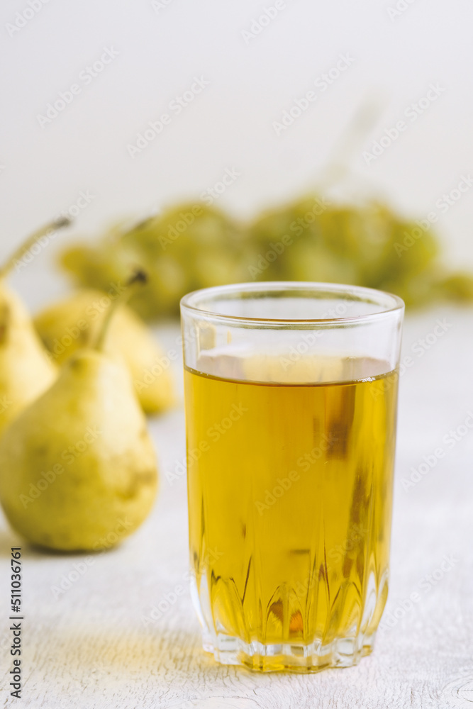 Juice of pears and grapes in a glass on a white wooden background Juice of pears and grapes in a glass on a white wooden background