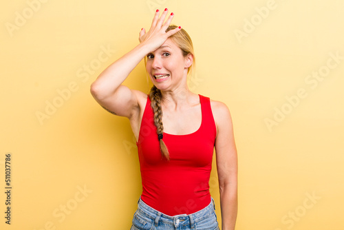 young adult  blonde woman raising palm to forehead thinking oops, after making a stupid mistake or remembering, feeling dumb photo