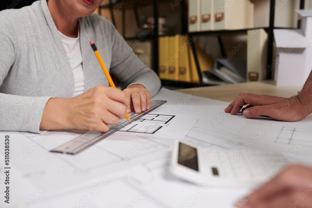 Architect measuring length of wall on house floor plan Architect measuring length of wall on house floor plan