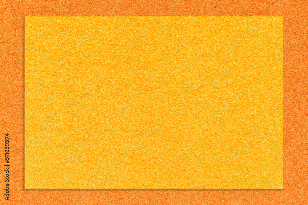 Texture of craft yellow paper background with orange border, macro. Structure of vintage dense kraft cardboard