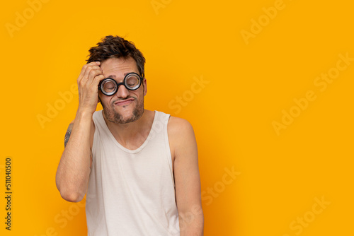 Funny myopic man wearing thick glasses with eyes closed and a thinking expression photo