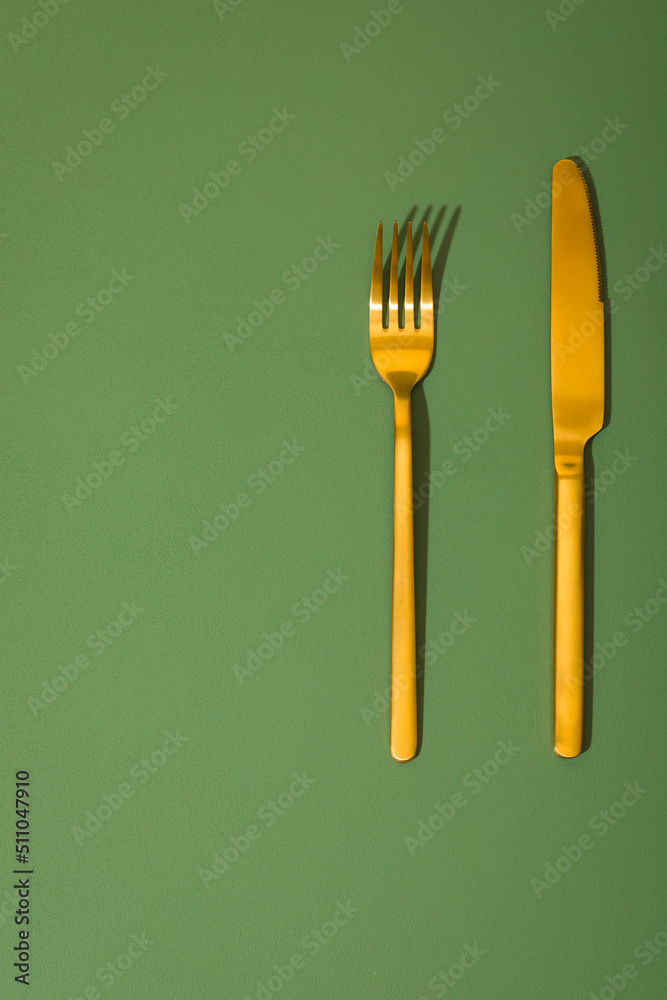 Golden cutlery set on the green background. Golden cutlery set on the green background.