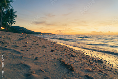 Sandy beach  surf and coastline at colorful sunset