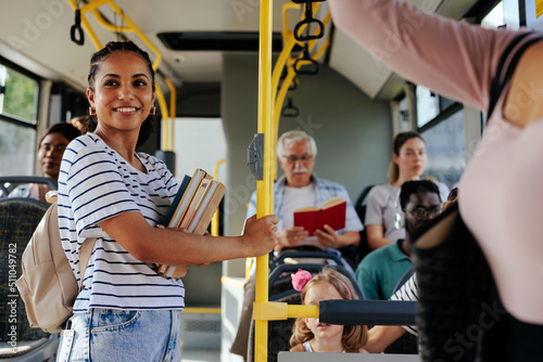 Fotografia Young smiling student in crowded bus