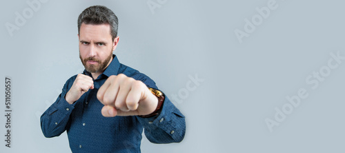 Stampa su tela Mature man stand in fighting position with clenched fists in business casual style, competition