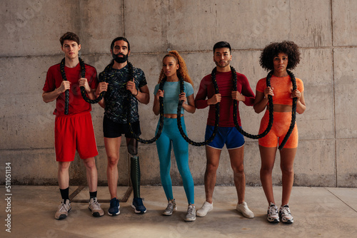 Diverse young sporty people with a battle rope