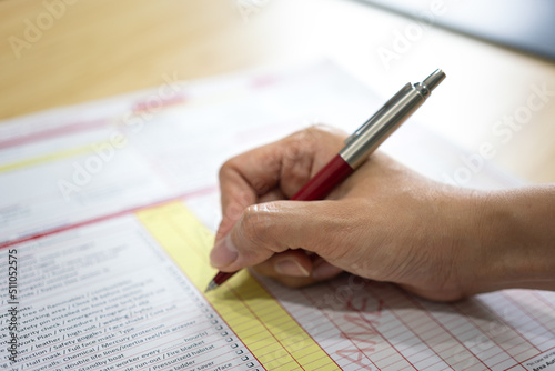 Foto Action of safety officer is using a pen to marking checklist in work permit document form