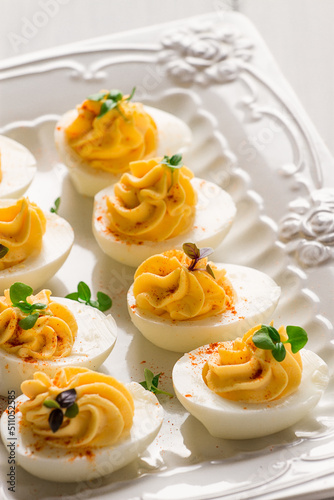 Boiled eggs stuffed with yolk with mayonnaise, on a white plate, selective focus, blurry, close-up, no people,