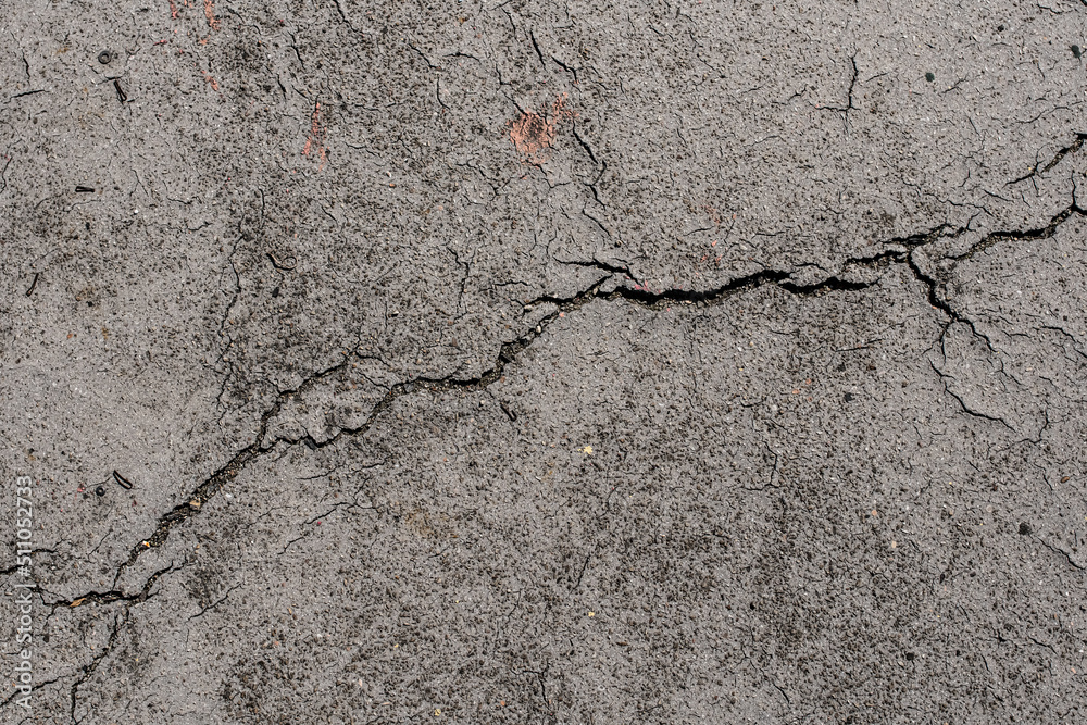 Fototapeta premium asphalt in cracks texture / abstract background cracks on asphalt road. Damaged and cracked asphalt ground background. Abstract aged road pattern detail.. Crack concrete texture surface background. 
