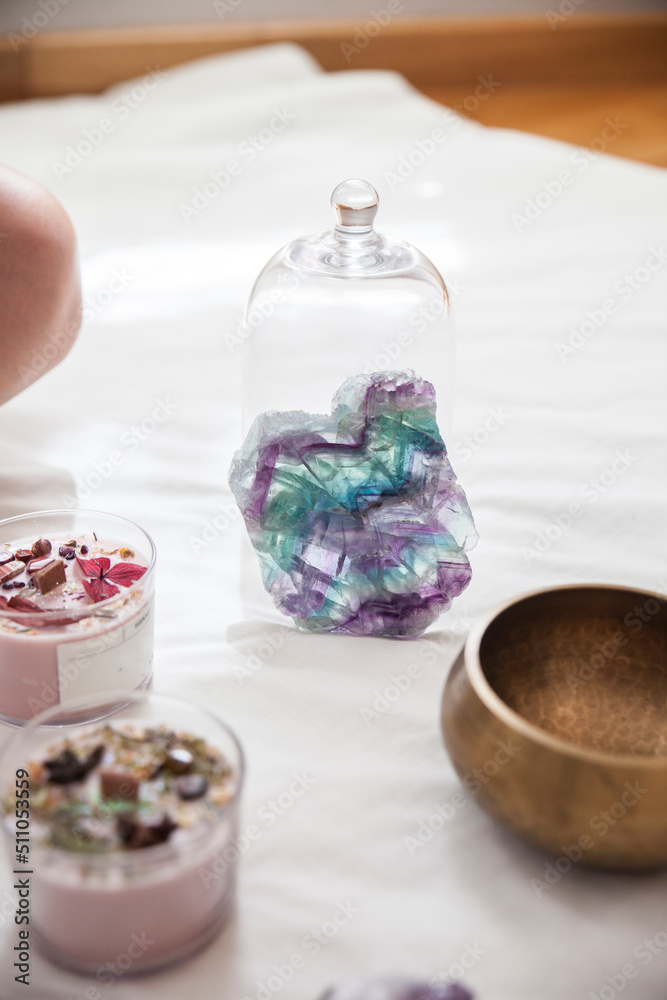 Backlit semiprecious stone. You can see all its shades of aquamarine, green, blue and violet. It is next to two beautiful decorated candles. Backlit semiprecious stone. You can see all its shades of aquamarine, green, blue and violet. It is next to two beautiful decorated candles.