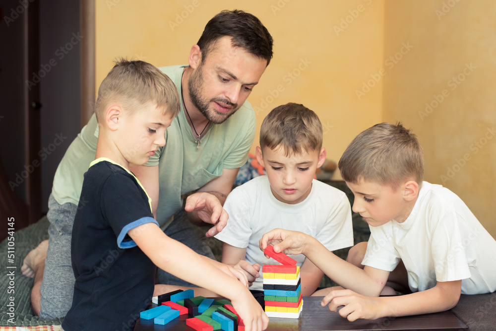 father playing with children, board game colored wooden cubes father playing with children, board game colored wooden cubes