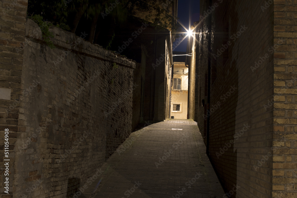 Narrow brick walkway in the city. Old Town at night. A romantic summer night at the castle Narrow brick walkway in the city. Old Town at night. A romantic summer night at the castle