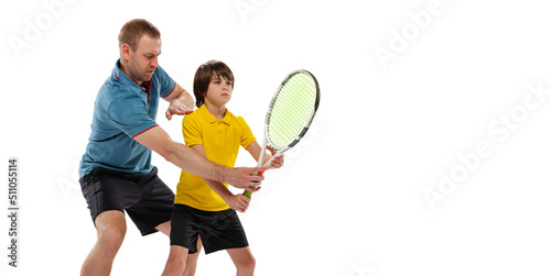 Male tennis player, coach training with teen to play tennis isolated over white studio background. Concept of sport, achievements, hobby, skills © master1305