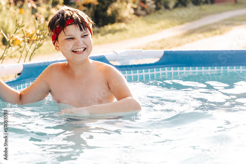 Portrait of smiling gen z Happy teen boy jumping in swimming pool at home backyard. Cute child toddler having fun enjoy summer time vacation laughing  yelling splashing water drops. Stay cooling off.