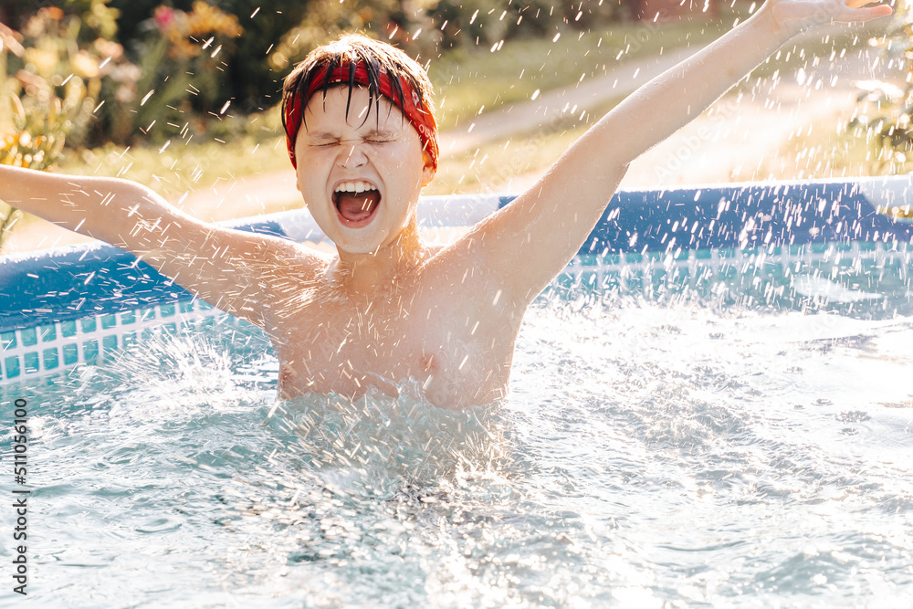 Portrait of smiling gen z Happy teen boy jumping in swimming pool at home backyard. Cute child toddler having fun enjoy summer time vacation laughing, yelling splashing water drops. Stay cooling off.