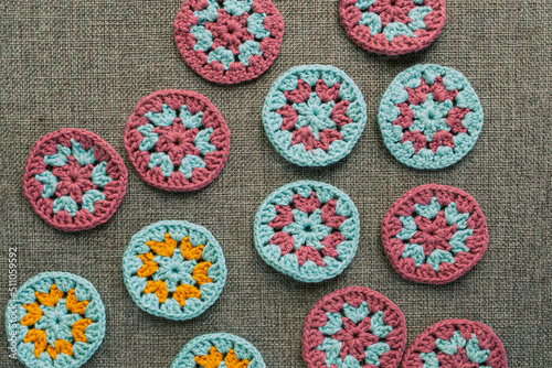 Top view of crochet circles  on grey textured fabric.