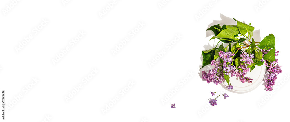 Lilac flowers bouquet on trendy stand isolated on a white background. Springtime concept