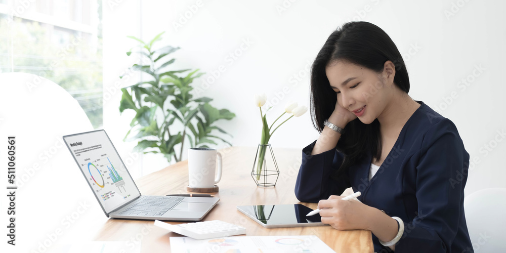 Beautiful young asian woman sitting at coffee shop using laptop. Happy young businesswoman sitting at table in cafe with tab top computer. Beautiful young asian woman sitting at coffee shop using laptop. Happy young businesswoman sitting at table in cafe with tab top computer.