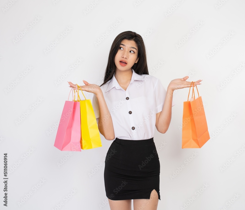 Portrait photo of a young beautiful cute young lady university student woman smile happily with colorful pink, yellow and orange color shopping bags Portrait photo of a young beautiful cute young lady university student woman smile happily with colorful pink, yellow and orange color shopping bags