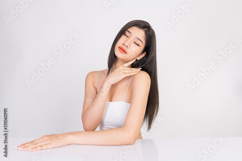 Portrait of a young, smart and very beautiful clean asian sexy female lady wearing white tank top with different elegant poses and emotions against a white studio background