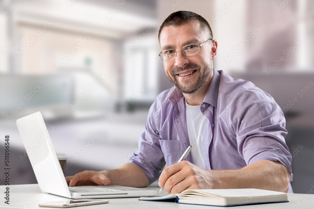 Satisfied business man working on computer at home workplace. Satisfied business man working on computer at home workplace.