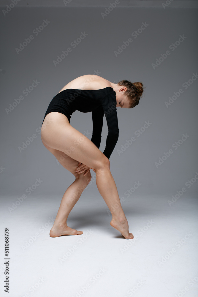 Young beautiful yoga female is exercising in classroom