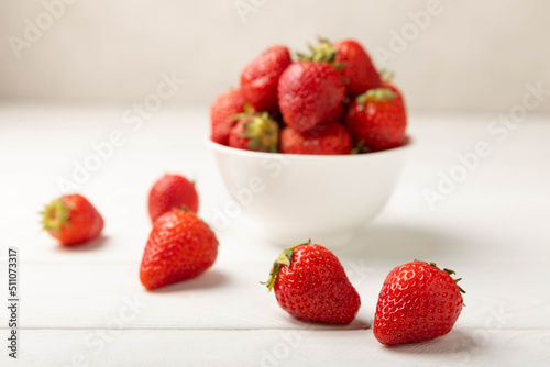 Fresh ripe strawberries in a plate on a white wooden background.Vegetarian organic berry.Healthy food.Vitamins.Copy space.Space for text