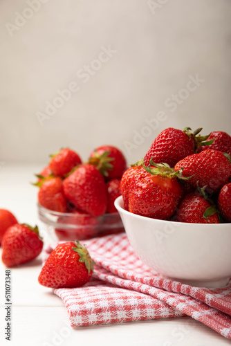 Fresh ripe strawberries in a plate on a white wooden background.Vegetarian organic berry.Healthy food.Vitamins.Copy space.Space for text