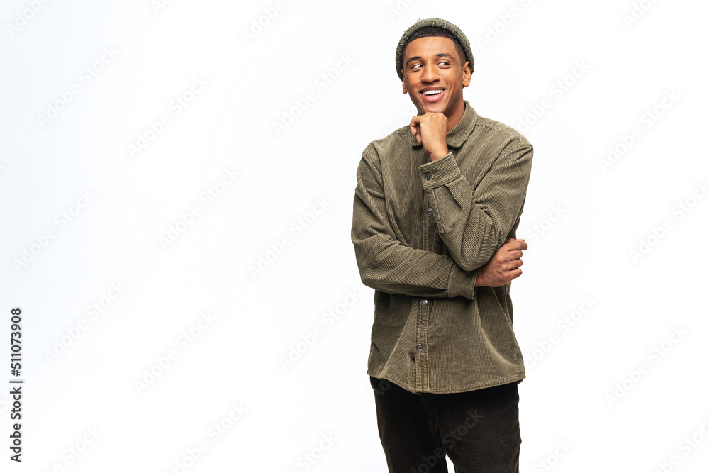 Thoughtful smiling African-American young man in shirt lost in dreams isolated on white. Friendly well-looking multiracial man holding hand near chin and looking for inspiration or new ideas Thoughtful smiling African-American young man in shirt lost in dreams isolated on white. Friendly well-looking multiracial man holding hand near chin and looking for inspiration or new ideas