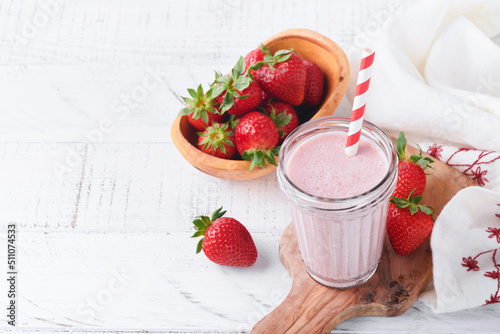 Strawberry smoothie. Vegan smoothie or milkshake from strawberry, banana and mint on white wooden table background. Clean eating, alkaline diet. Top view. Mock up. photo