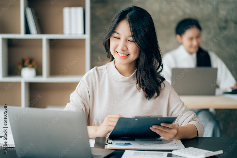 Asian businesswoman in formal suit in office happy and cheerful during using smartphone and working Asian businesswoman in formal suit in office happy and cheerful during using smartphone and working