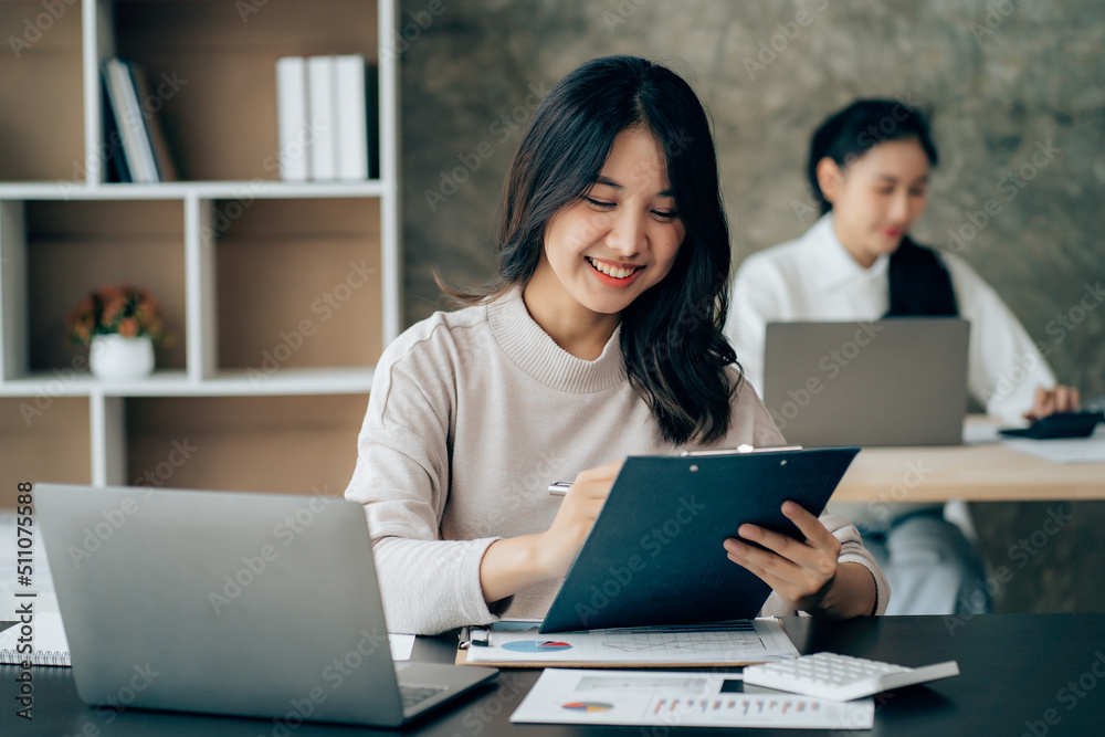 Asian businesswoman in formal suit in office happy and cheerful during using smartphone and working Asian businesswoman in formal suit in office happy and cheerful during using smartphone and working