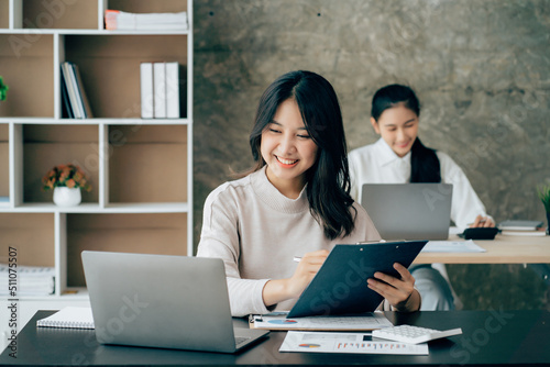 Asian businesswoman in formal suit in office happy and cheerful during using smartphone and working