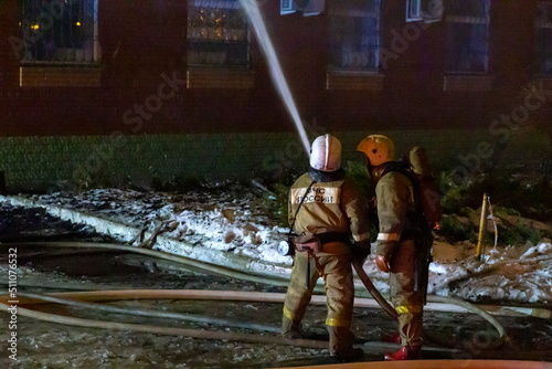Russia Samara January 2020: EMERCOM employees extinguish a fire at night in winter. photo