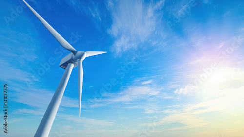 Low angle of wind turbine against bright blue sky. Renewable or green energy concept. landscape of windmill with sunlight and almost clear sky.