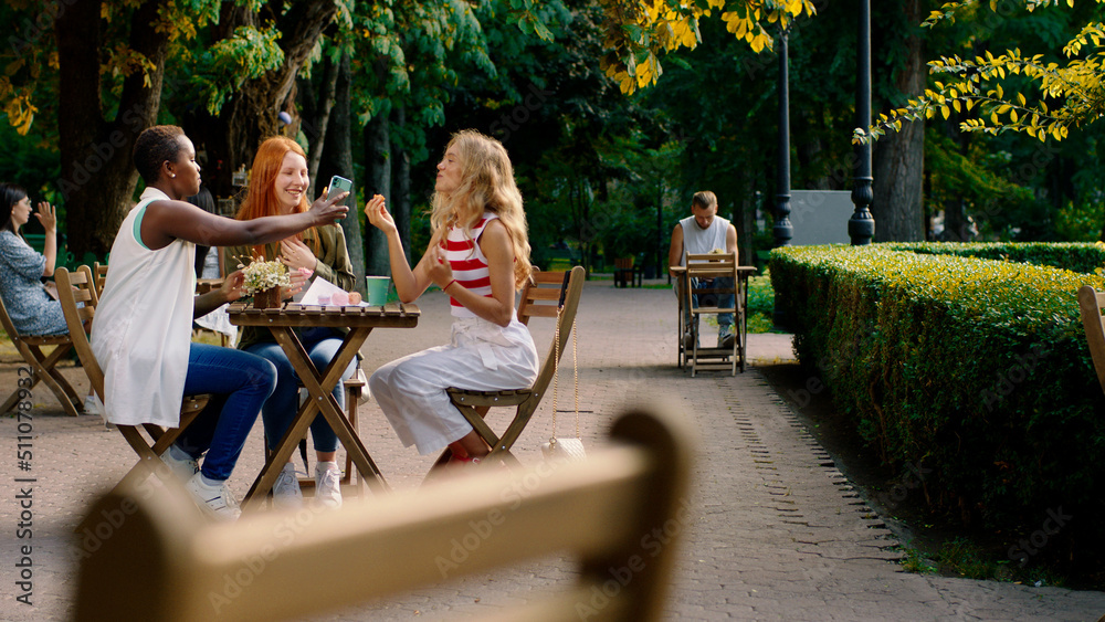Amazing ladies very beautiful multiethnic enjoy the time together in the middle of park at cafe they have a conversation all together Amazing ladies very beautiful multiethnic enjoy the time together in the middle of park at cafe they have a conversation all together