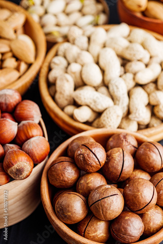 set of different nuts on a black rustic wooden background