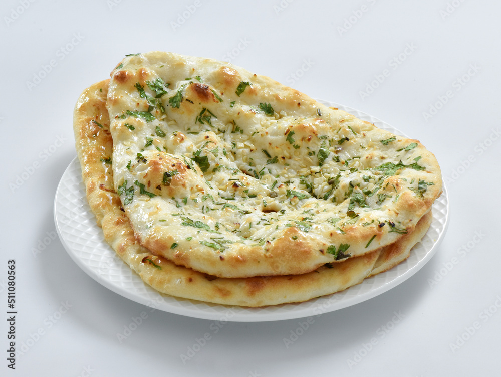 Garlic Naan Bread, A traditional Indian bread prepared with wheat flour, garlic, and coriander and baked in a vertical clay oven (tandoor), and then brushed with butter. Garlic Naan Bread, A traditional Indian bread prepared with wheat flour, garlic, and coriander and baked in a vertical clay oven (tandoor), and then brushed with butter.