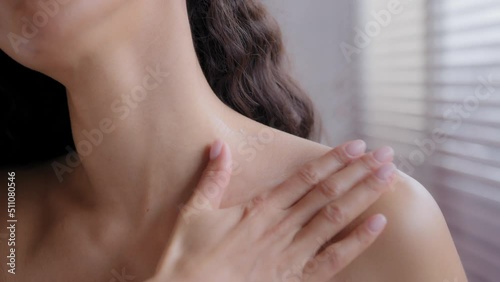 Close-up beautiful unrecognizable nude sensual young woman treating neck and shoulder with moisturizing cream massages body skin care daily cosmetic procedure rubs lotion bodycare applying moisturizer