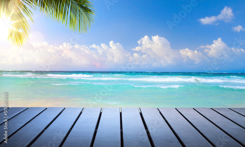 Art beautiful summer tropical holiday background; suny sandy beach, palm tree and wooden deck